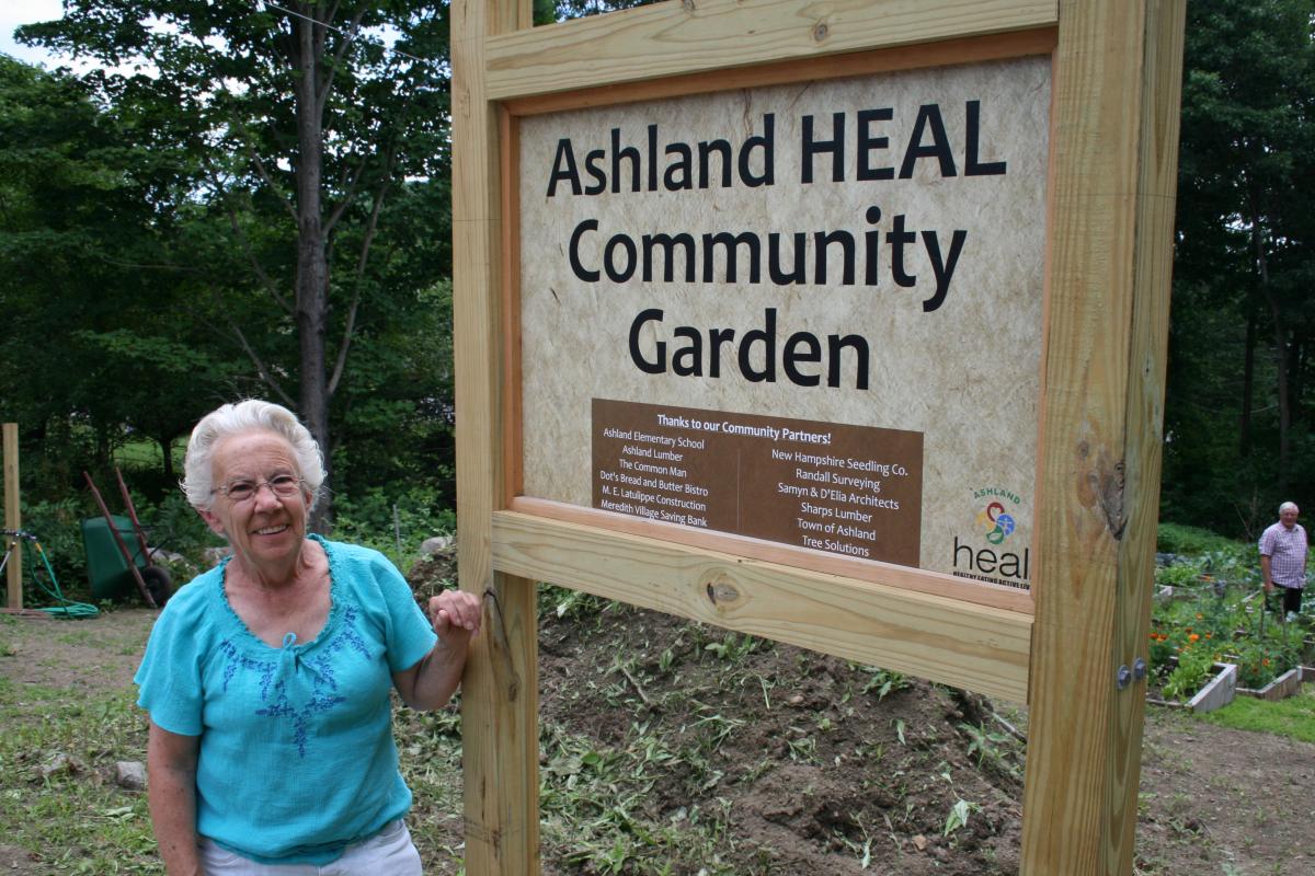 Community gardener and sign