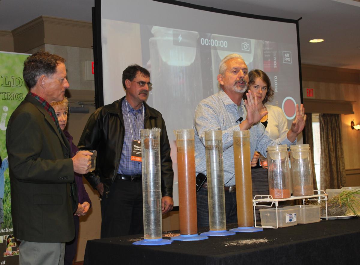 Ray Archuleta, Conservation Agronomist at the USDA Natural Resources and Conservation Service, demonstrates a soil stability test with Vermont farm and food industry leaders at the 2015 Farm to Plate Annual Gathering