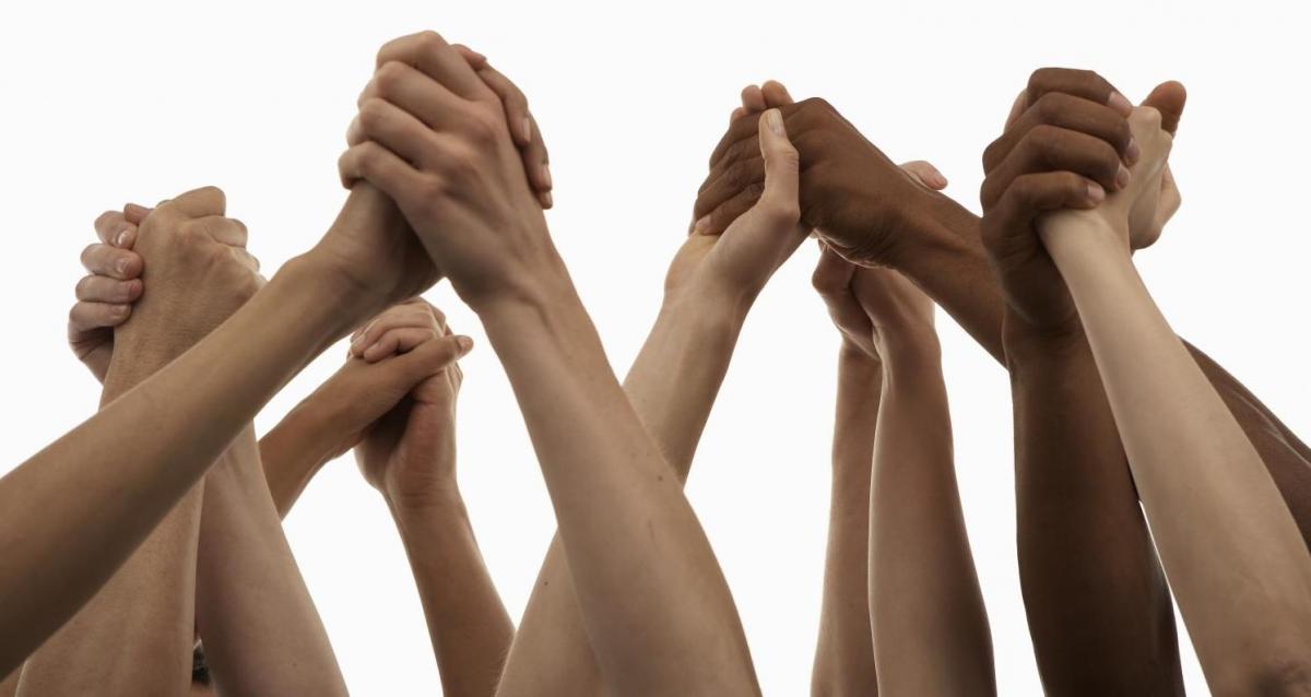 diverse hands joined, raised