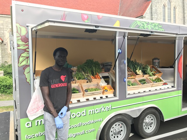 Munir in front of produce display 