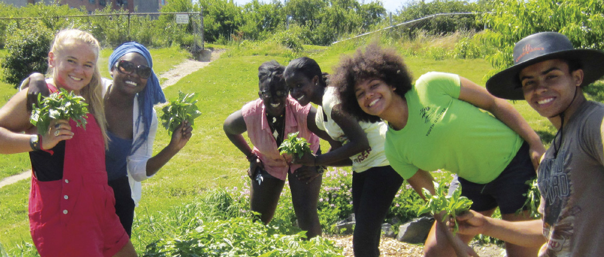 A group of smiling volunteer planters captioned “Building racial equity and justice across the New England food system”