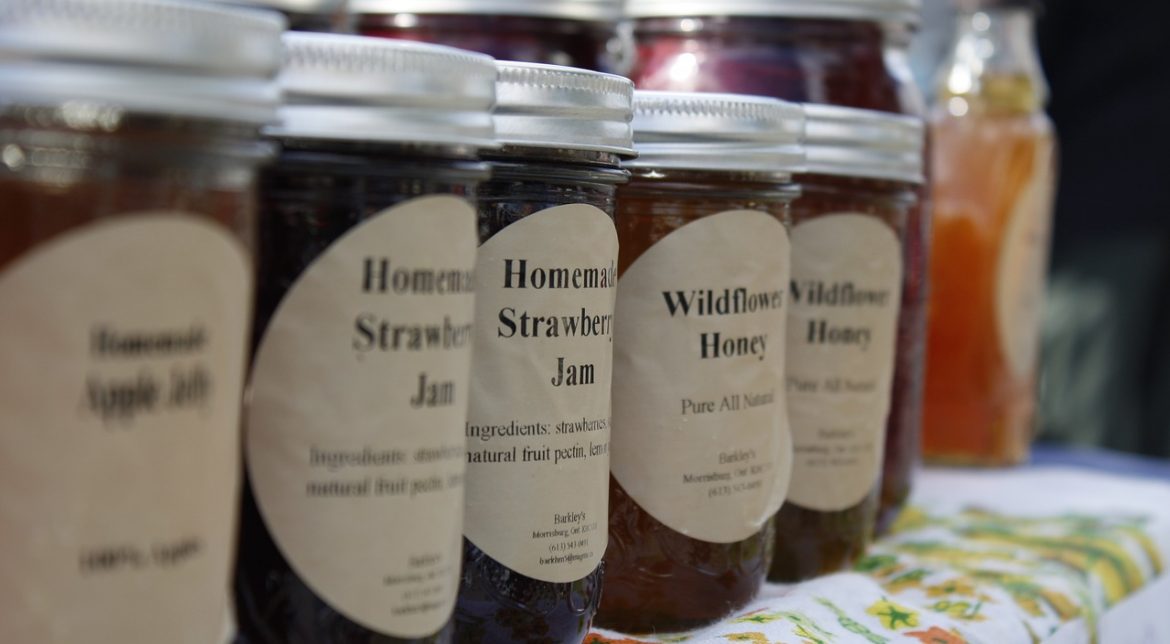 Close-up of a row of jars of locally made jams, jellies, and honey