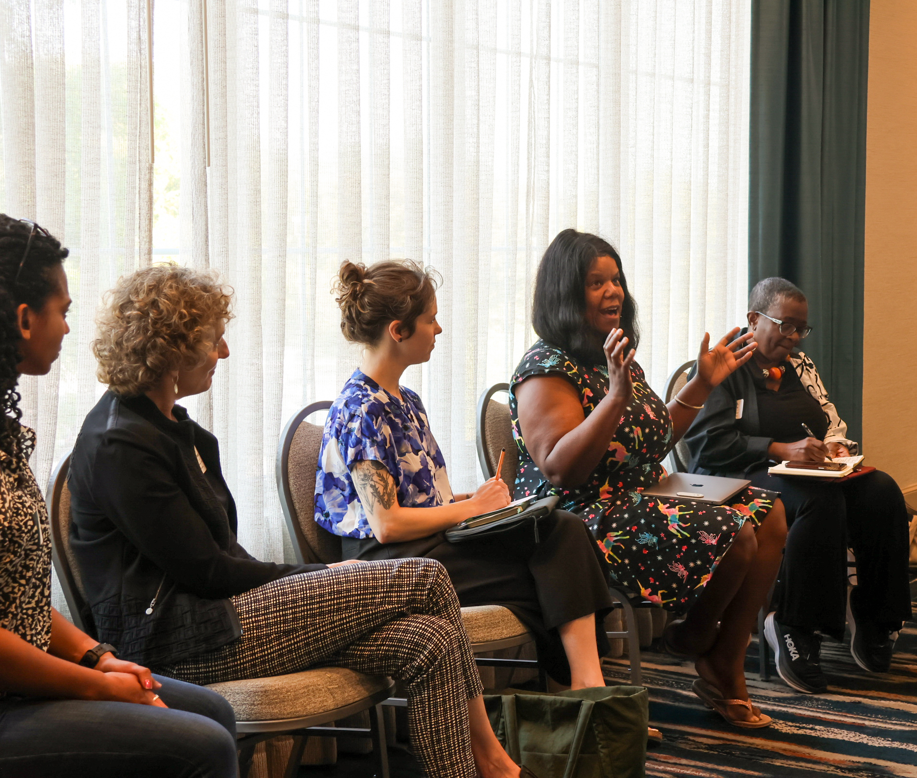 People sit around a presentation at food systems research summit and share.