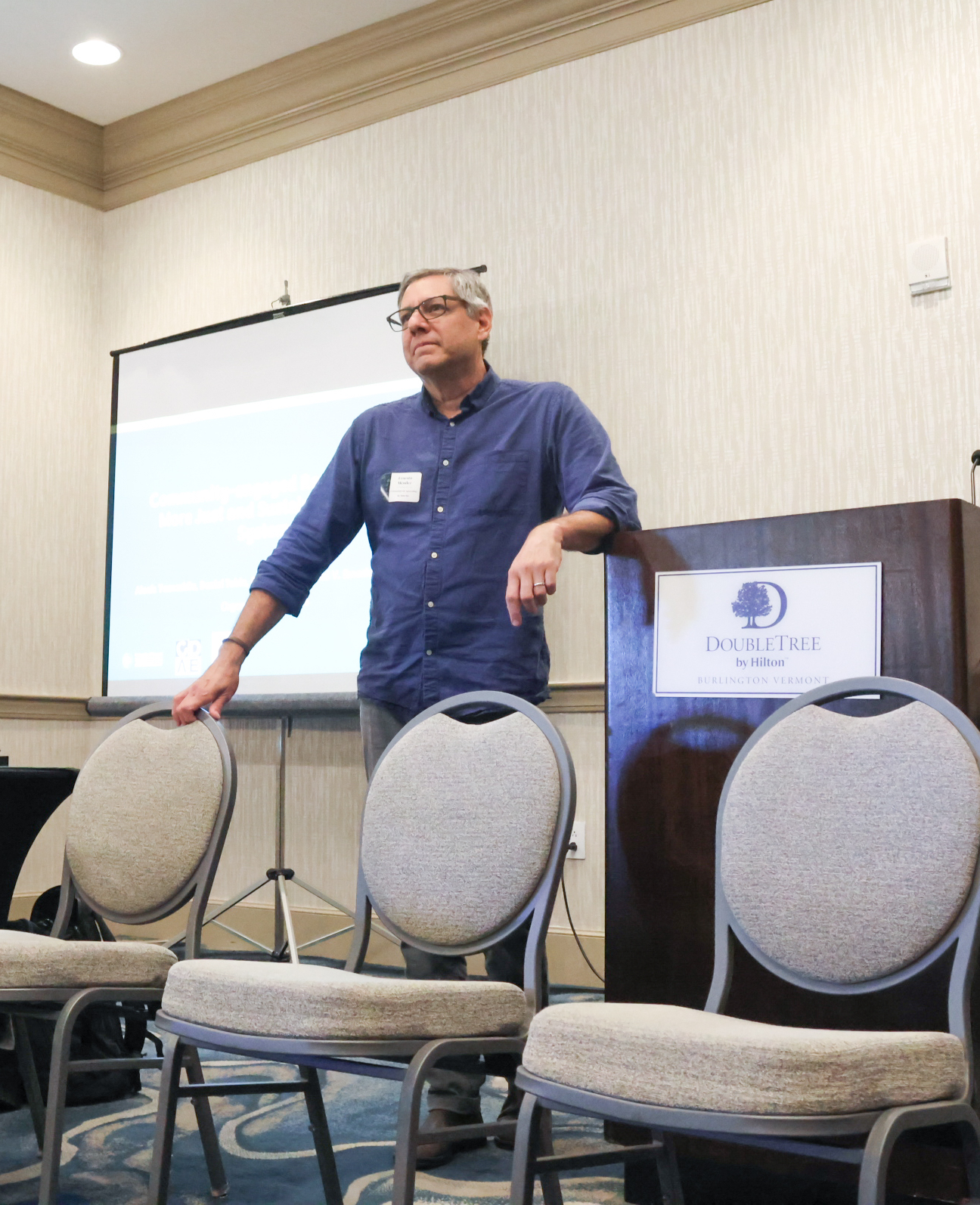 Ernesto from Institute for Agroecology stands behind some chairs at a podium at food systems research summit